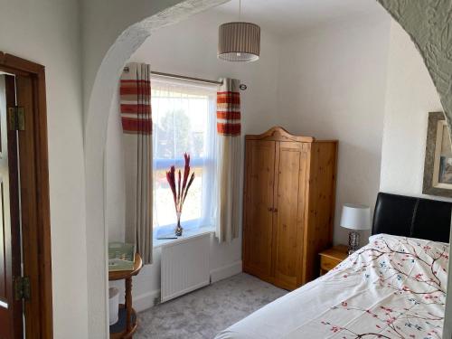 a bedroom with a bed and a window at Crispin House in Hunstanton
