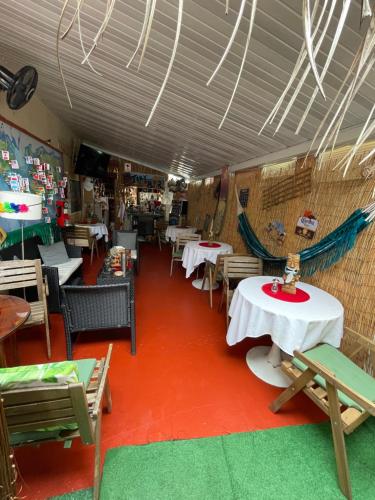 a restaurant with white tables and chairs and a red floor at Habitación Céntrica calle 8 Miami in Miami