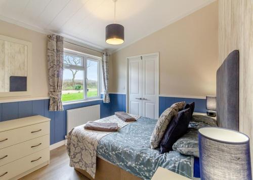Schlafzimmer mit einem Bett, einem Schreibtisch und einem Fenster in der Unterkunft Camper Uk Leisure Park in Doddington