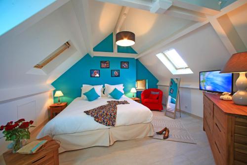 une chambre avec un grand lit avec un mur bleu dans l'établissement Les Terrasses du Domaine de la Malonie, à Sarlat-la-Canéda