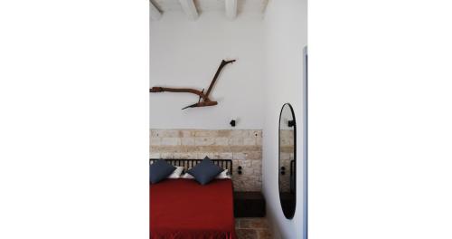 a bedroom with a red bed and a brick wall at Casale Petrarolo in Monopoli