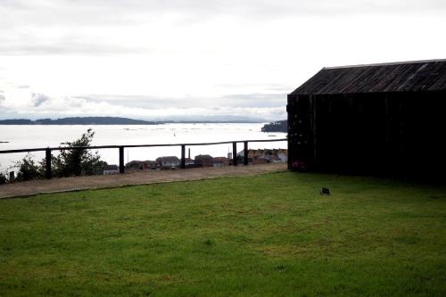 a black building with a view of the water at Cabañas Rias Baixas in Pobra do Caramiñal