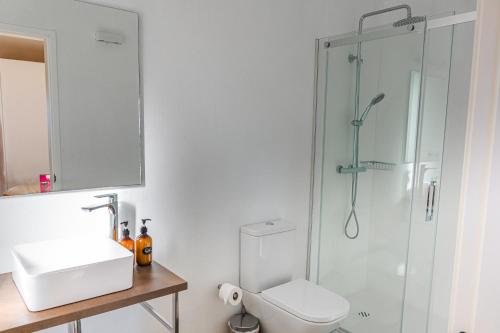 a bathroom with a shower and a toilet and a sink at Cabañas Rias Baixas in Pobra do Caramiñal