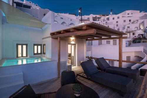 une villa avec une piscine au-dessus d'une maison dans l'établissement Aqua Luxury Suites Santorini, à Imerovigli