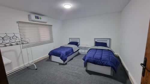 Cette chambre comprend 2 lits et une fenêtre. dans l'établissement Stay Classy Apartments, à Wadi Musa