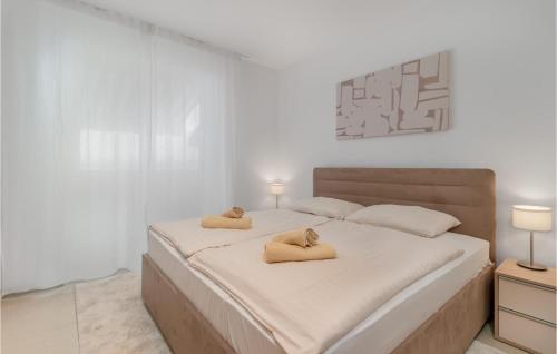 a white bedroom with a large bed with two pillows at Amazing Apartment In Selce With House Sea View in Selce