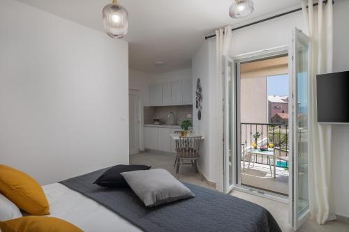 a bedroom with a bed and a kitchen with a balcony at Villa Mirta in Bol
