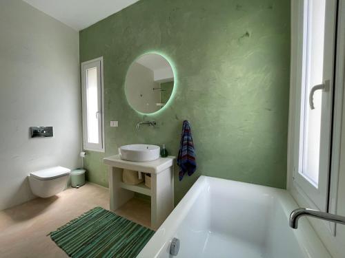 a bathroom with a tub and a sink and a mirror at The Velanidies - Οι Βελανιδιές in Agia Marina