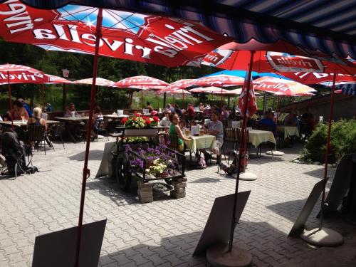 a group of people sitting at tables under umbrellas at Pension Aaron am See in Grächen