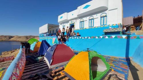 eine Gruppe von Zelten an einem Strand neben einem Gebäude in der Unterkunft Ramy Heissa Nubian house in Assuan