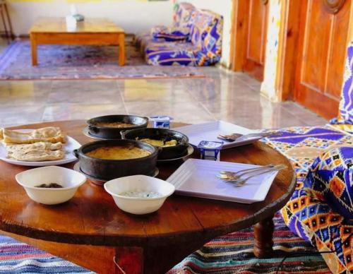 una mesa de madera con tazones de comida. en Ramy Heissa Nubian house, en Asuán