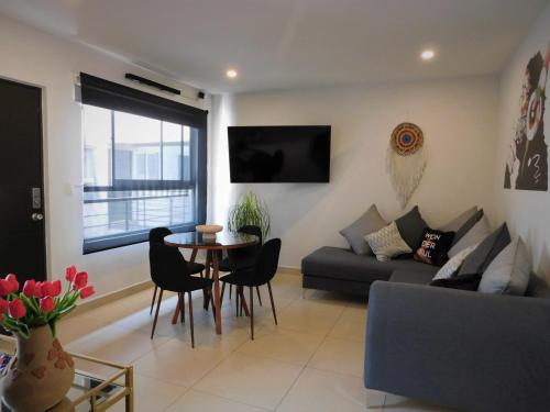 a living room with a couch and a table and chairs at #1 Cozy depa Aeropuerto Estadio GNP -Foro Sol- in Mexico City