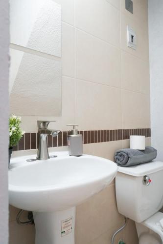 a bathroom with a white sink and a mirror at Bella Residencial Arco Antiguo Yautepec in Itzamatitlán