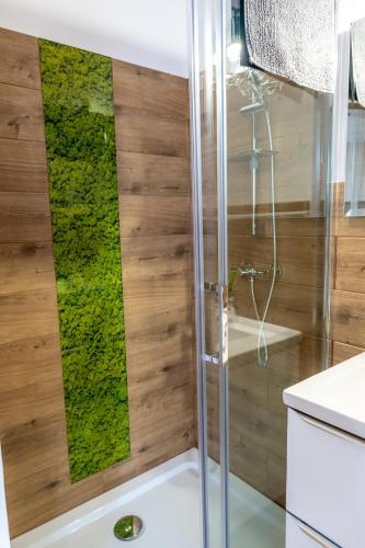 a bathroom with a shower with green moss on the wall at Dolina Dunajca in Tylmanowa