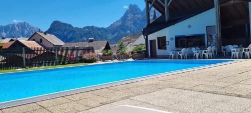 a swimming pool in front of a house with mountains at Xeis NeSt in Admont