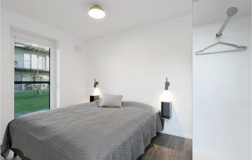 a white bedroom with a bed and a window at Lovely Apartment In Lembruch-dmmer See With Wifi in Lembruch