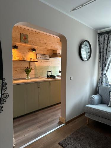 a kitchen with a clock on the wall and a couch at RL Guesthouses in Geilenkirchen