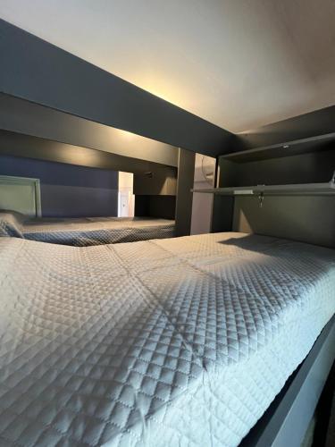 1 dormitorio con 1 cama blanca grande. en Wynwood Extreme Hostel en Villa Carlos Paz