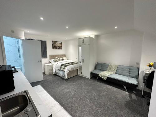 a bedroom with a bed and a couch in a room at Regent Luxury Studio in Coventry