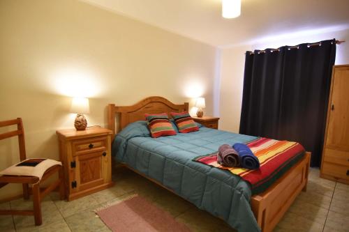 a bedroom with a bed with two pillows on it at Hostal Ayni in San Pedro de Atacama