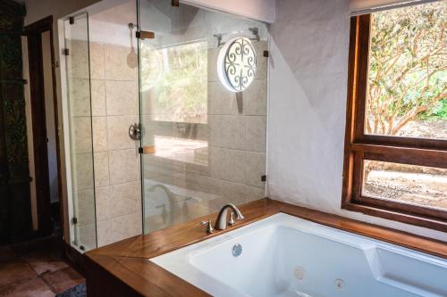 a bathroom with a tub and a glass shower at Finca La Hacienda in El Retiro