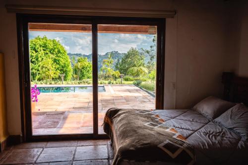 a bedroom with a sliding glass door to a pool at Finca La Hacienda in El Retiro