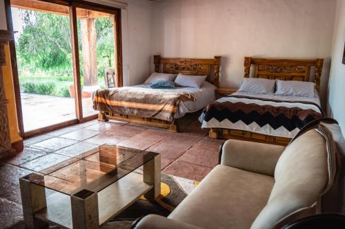 sala de estar con 2 camas y mesa de cristal en Finca La Hacienda en El Retiro