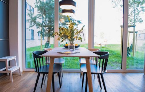 レンブルッフにあるLovely Apartment In Lembruchdümmer Seeのテーブルと椅子と大きな窓のあるダイニングルーム