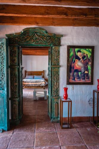 a room with a bed and a painting on the wall at Finca La Hacienda in El Retiro