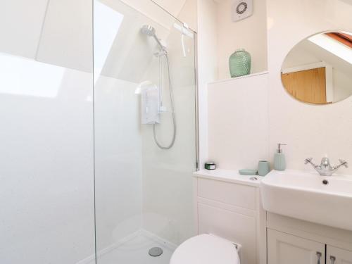 a bathroom with a shower and a toilet and a sink at Bayview Loft in Weymouth