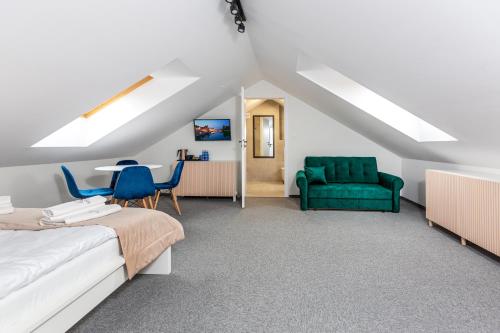 a bedroom with a bed and a green chair at KASHUBIAN Resort in Władysławowo