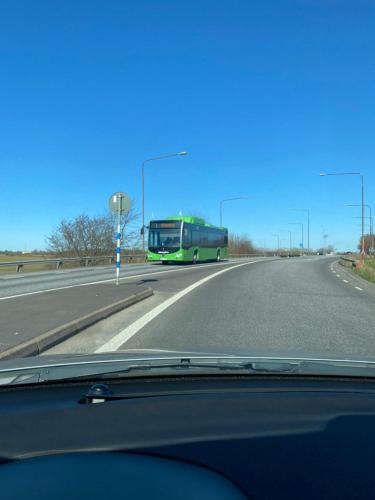 a green bus driving down the road at Bli Hel in Malmö