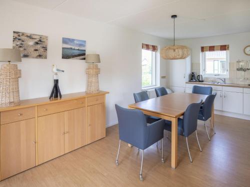 uma cozinha e sala de jantar com uma mesa de madeira e cadeiras em Holiday home near Grevelingen Lake em Zonnemaire