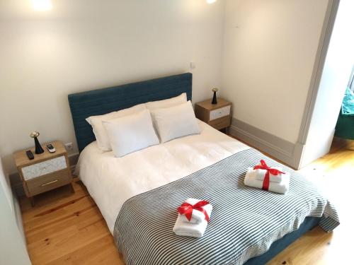a bedroom with a bed with two presents on it at Lusitania Garden Apartment - Jardim Privado in Porto
