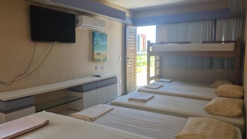 a room with two beds and a tv and a window at Casa Aeroclube in João Pessoa