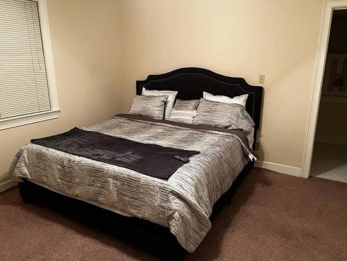 um quarto com uma cama com uma cabeceira e almofadas pretas em Southern Hospitality em Albany