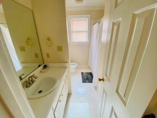 uma casa de banho branca com um lavatório e um espelho em Southern Hospitality em Albany