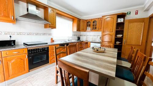 a kitchen with wooden cabinets and a wooden table at Villa Pedro by Sunny Deluxe in Albufeira