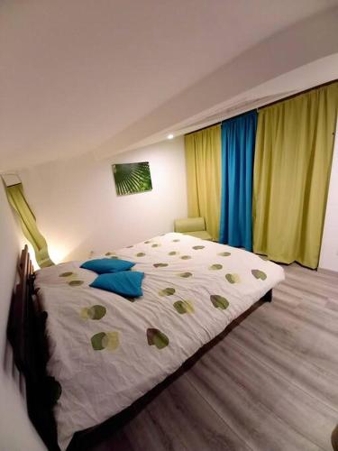 - une chambre dotée d'un grand lit avec des oreillers jaunes et bleus dans l'établissement Maison entre Océan - Bassin d'arcachon, à Le Porge