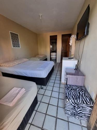 a room with two beds and a tv in it at Casa Aeroclube in João Pessoa