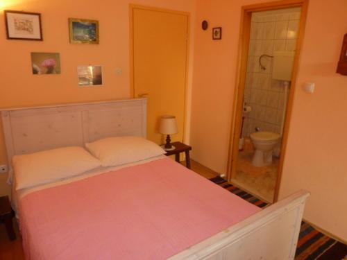 a bedroom with a bed and a bathroom with a toilet at Studio Orange in Zavala