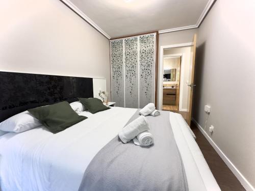 a bedroom with a large white bed with towels on it at Villa Mercedes - 17001 in Santoña