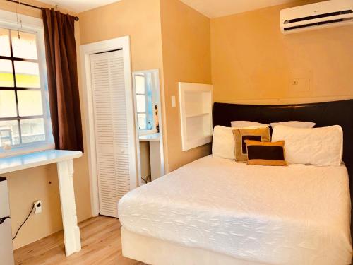 sypialnia z łóżkiem z białą pościelą i oknem w obiekcie Island Retreat Studio #5 w mieście Nassau