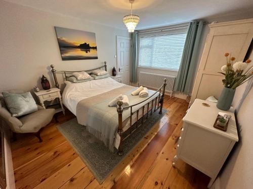 ein Schlafzimmer mit einem Bett, einem Stuhl und einem Fenster in der Unterkunft Laburnum Cottage in Alnwick