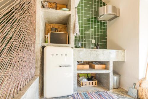 a small white refrigerator in a room with a wall at Obidos Rural Chic House in Usseira