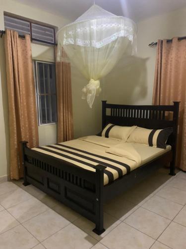 Bett in einem Zimmer mit Vorhängen und einem Bett sidx sidx sidx sidx in der Unterkunft Larry's Place - Gulu , Uganda in Gulu