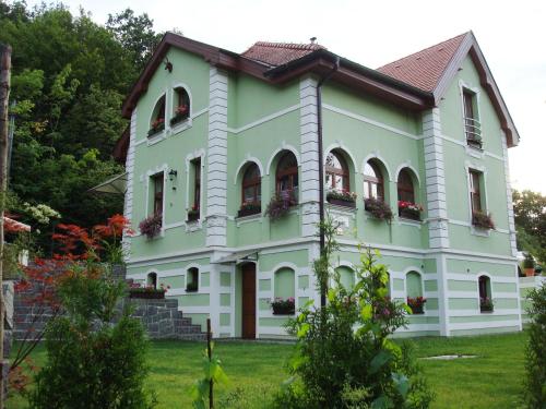 a large white house with flowers in the windows at Penzión Zlatý Jeleň in Košice