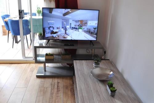 uma televisão de ecrã plano numa bancada numa sala de estar em The RedBridge House em Swindon