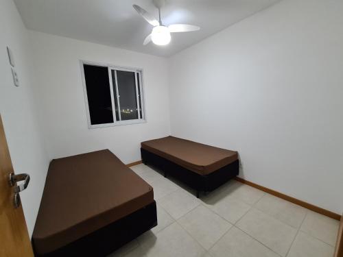 a room with two beds and a window at 301 Lugar de Veraneio in Serra