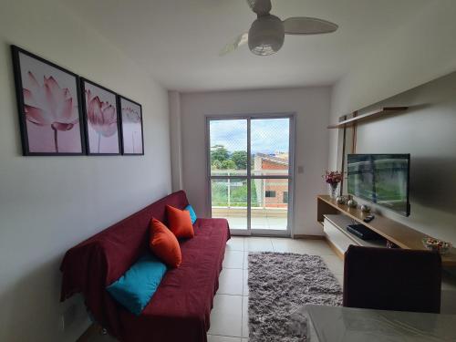 a living room with a red couch and a tv at 301 Lugar de Veraneio in Serra